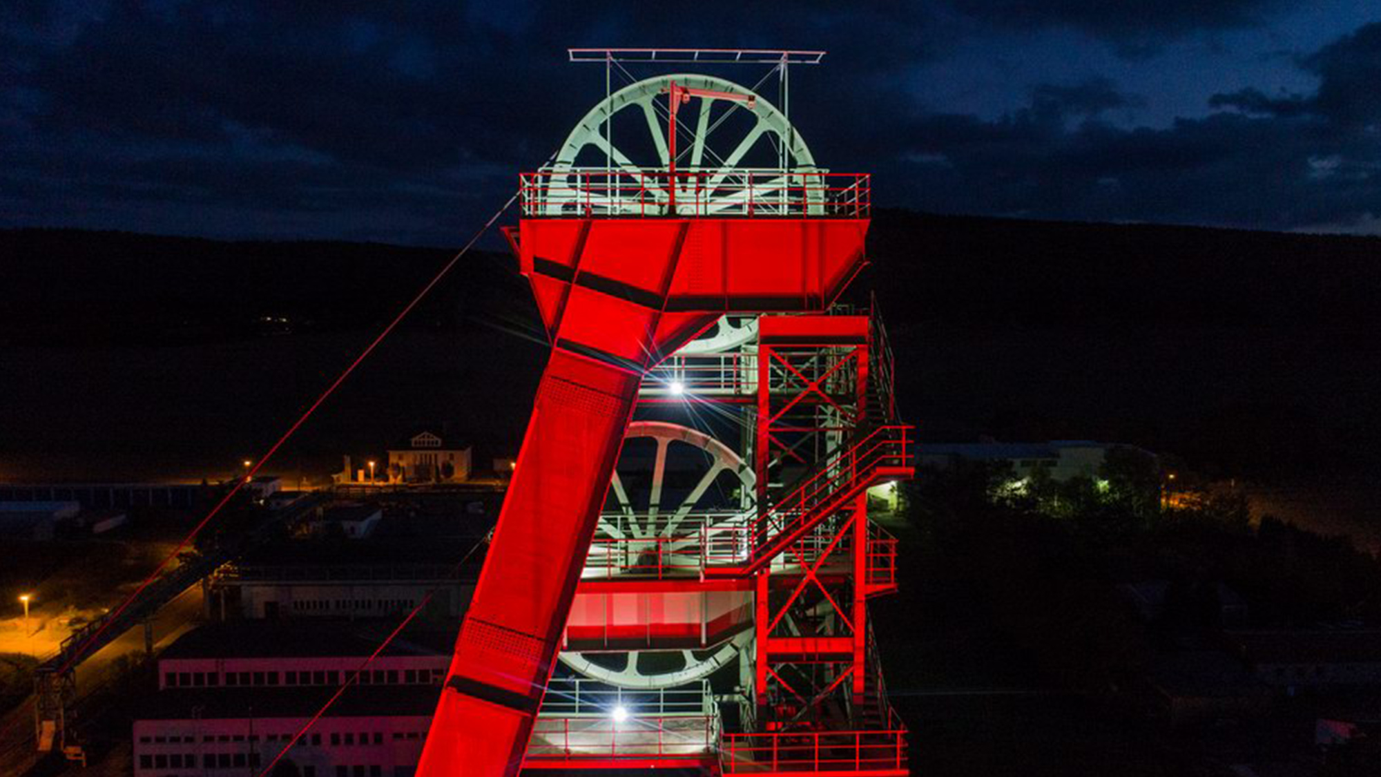 Rot angeleuchteter Förderturm in der Nacht